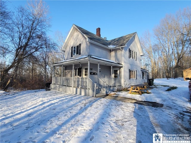 view of front of house featuring covered porch and a chimney