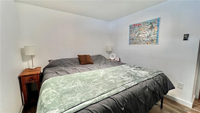 bedroom featuring baseboards and wood finished floors