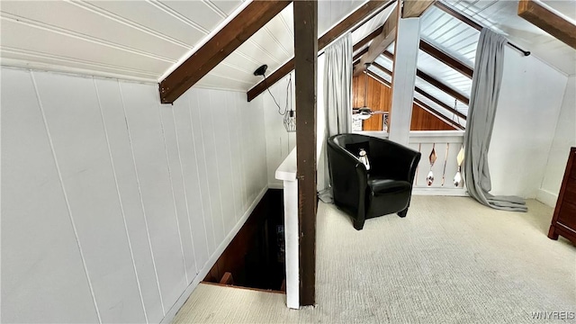 interior space with lofted ceiling with beams, carpet floors, and wood walls