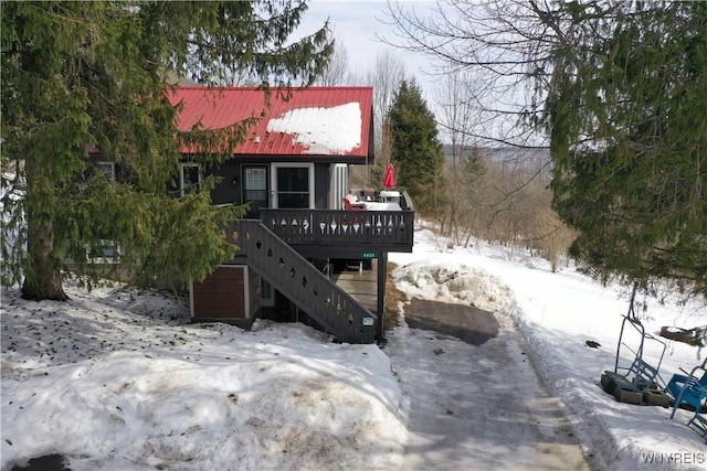 rustic home with metal roof, stairway, and a wooden deck