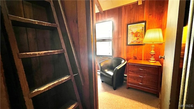 home office featuring wood walls, baseboard heating, and light colored carpet