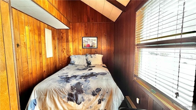 bedroom with vaulted ceiling and wood walls