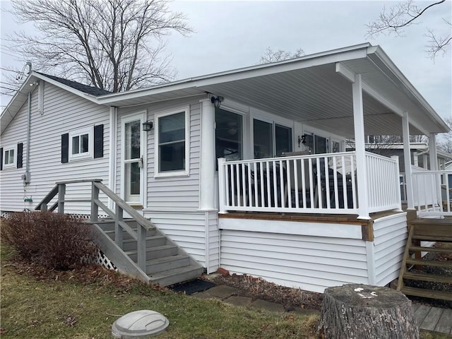 view of side of property featuring covered porch