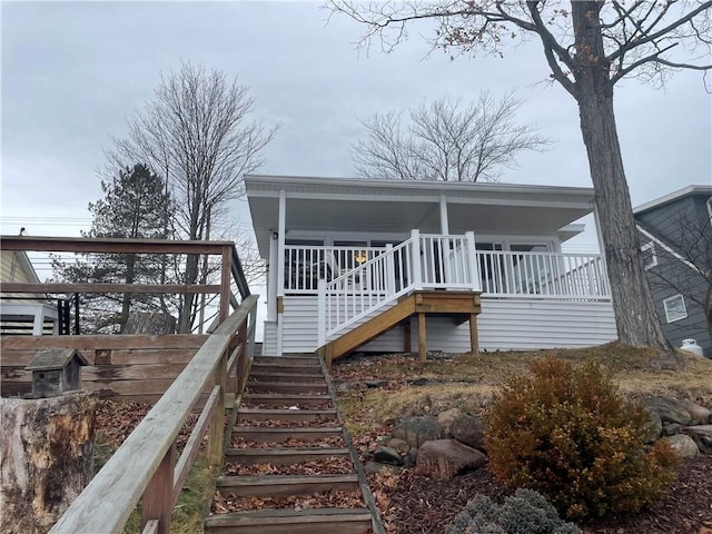 rear view of house featuring a porch and stairs