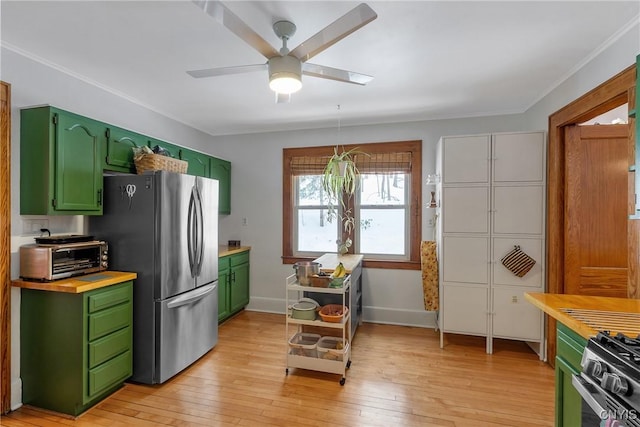 kitchen with green cabinets, light wood-type flooring, gas stove, and freestanding refrigerator