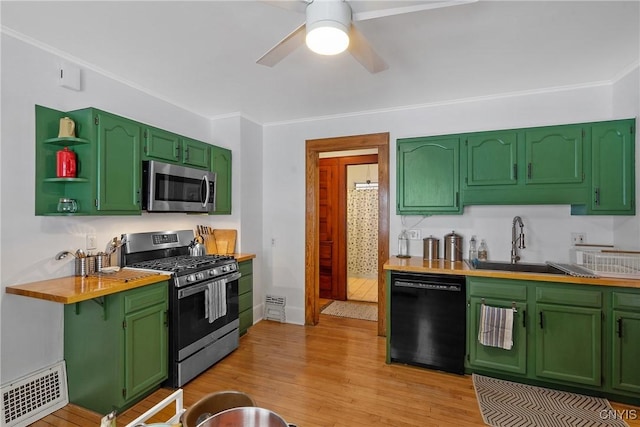 kitchen featuring stainless steel appliances, a sink, visible vents, and green cabinetry