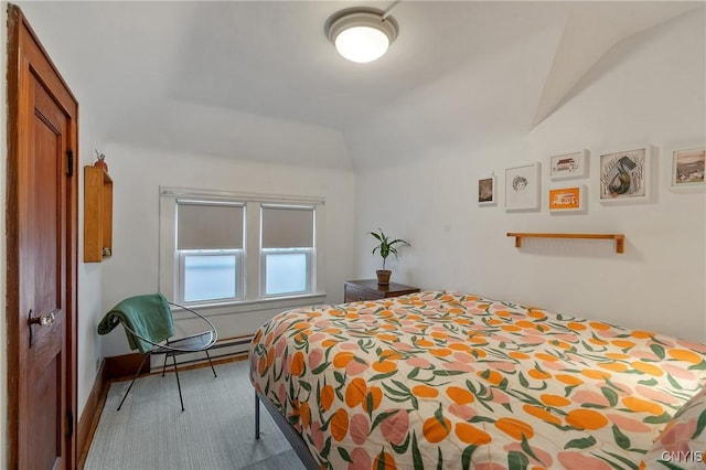 bedroom with lofted ceiling and a baseboard heating unit