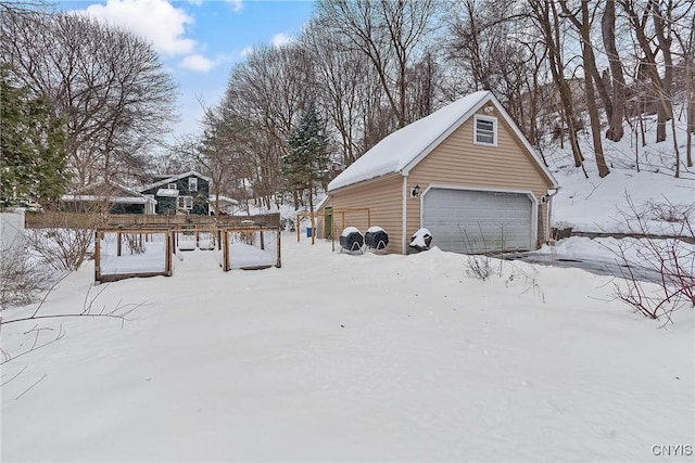 yard covered in snow with an outbuilding and a detached garage