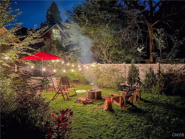 view of yard with an outdoor fire pit and fence