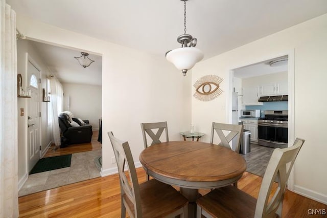 dining room featuring light wood-style flooring and baseboards