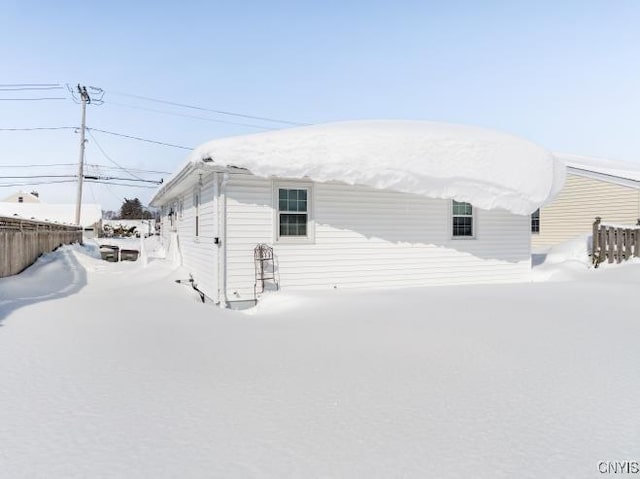 snow covered property with fence