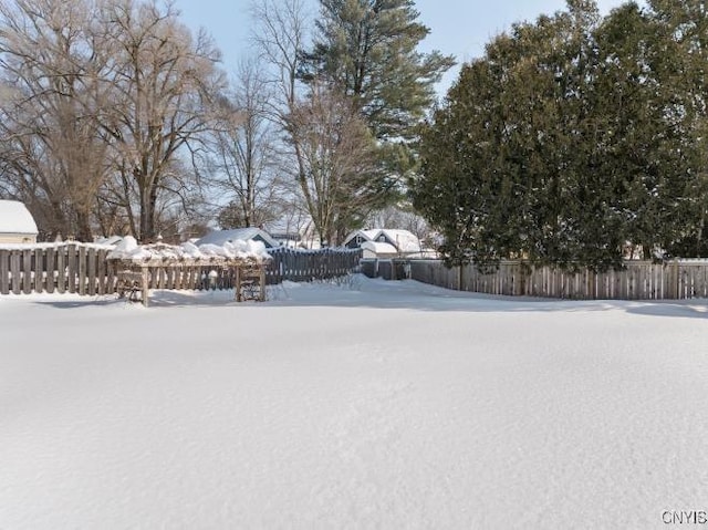 yard covered in snow featuring fence