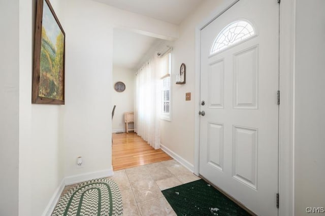 entryway with light tile patterned flooring and baseboards