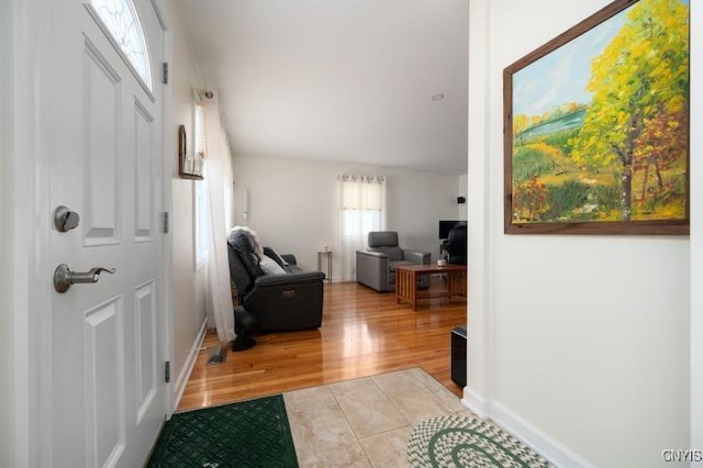 foyer entrance featuring light wood-style flooring and baseboards