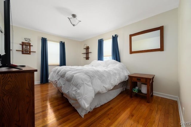 bedroom featuring wood finished floors and baseboards