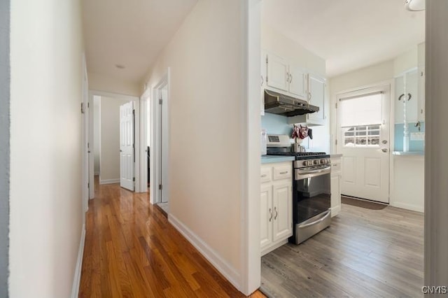 hallway featuring baseboards and wood finished floors