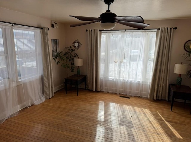 unfurnished room with light wood finished floors, plenty of natural light, and visible vents