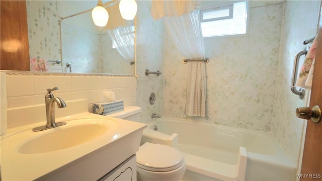 bathroom featuring tile walls, bathing tub / shower combination, toilet, vanity, and wallpapered walls