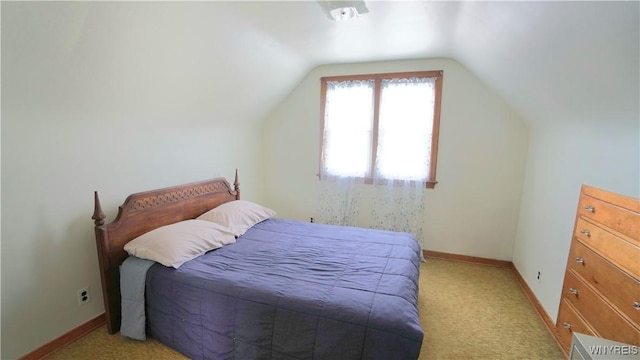 bedroom featuring light carpet, baseboards, and vaulted ceiling