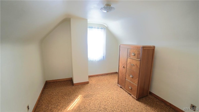 bonus room featuring light colored carpet, vaulted ceiling, and baseboards