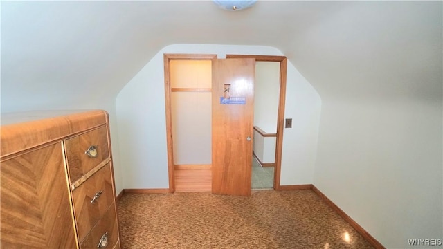 bonus room featuring lofted ceiling, carpet flooring, and baseboards