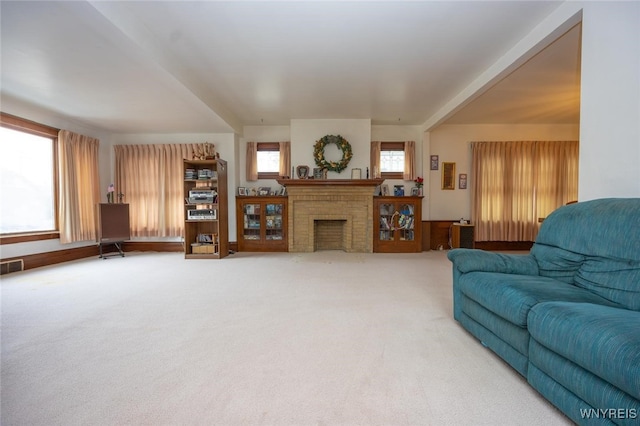 living room with a fireplace, carpet flooring, and visible vents