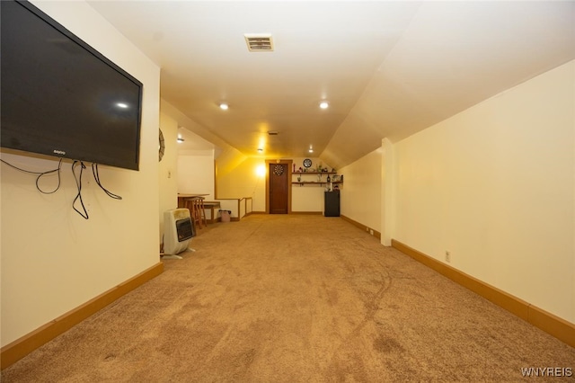 below grade area featuring heating unit, baseboards, light carpet, and visible vents