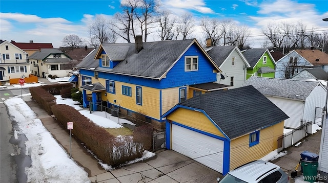 exterior space with a garage, a chimney, fence, and a residential view