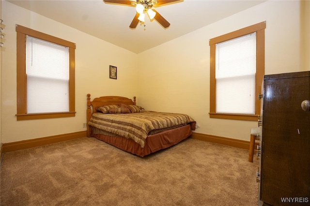 carpeted bedroom featuring baseboards and a ceiling fan