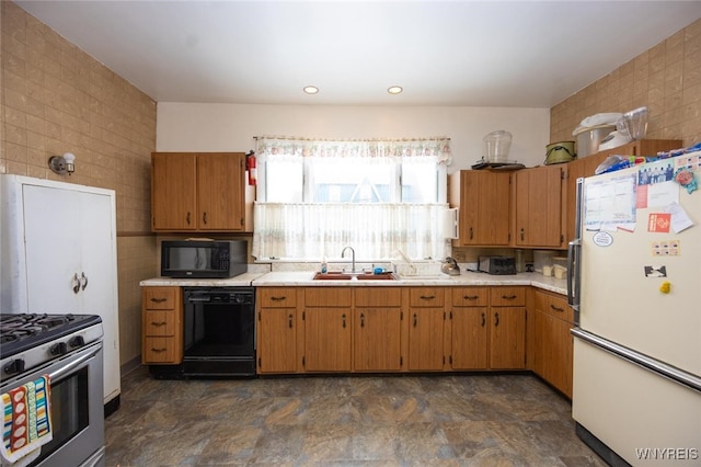 kitchen with black appliances, tile walls, light countertops, and a sink