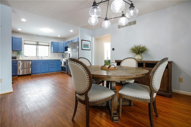 dining area featuring dark wood finished floors, recessed lighting, visible vents, an inviting chandelier, and baseboards