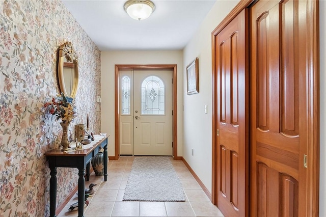 foyer entrance featuring light tile patterned flooring and baseboards