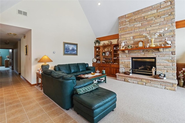 tiled living area featuring high vaulted ceiling, visible vents, a fireplace, and baseboards