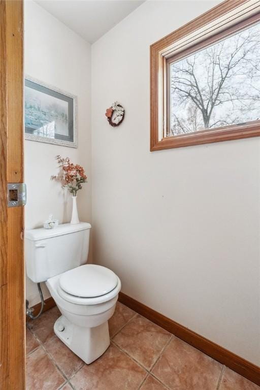 bathroom with toilet, tile patterned flooring, and baseboards