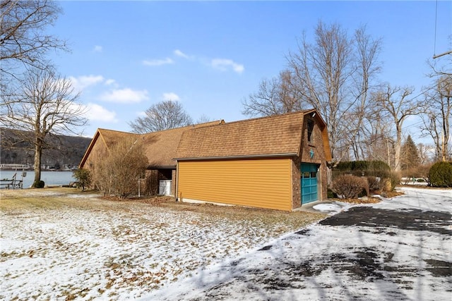 view of front of house featuring a shingled roof, an outbuilding, and a gambrel roof