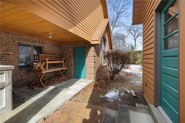 exterior space with roof with shingles and brick siding