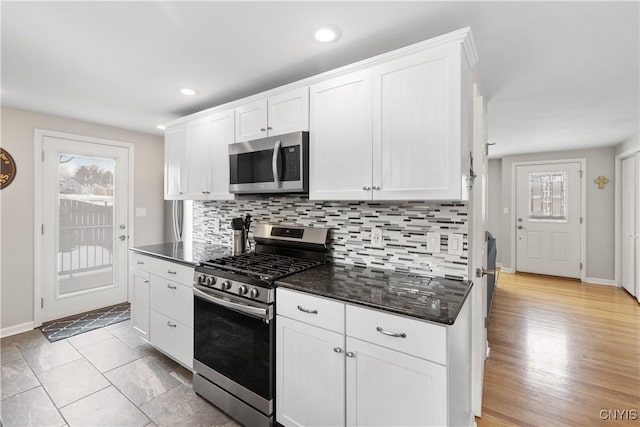 kitchen featuring tasteful backsplash, appliances with stainless steel finishes, baseboards, and white cabinets