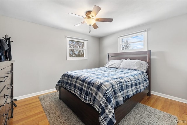 bedroom featuring a ceiling fan, baseboards, and wood finished floors