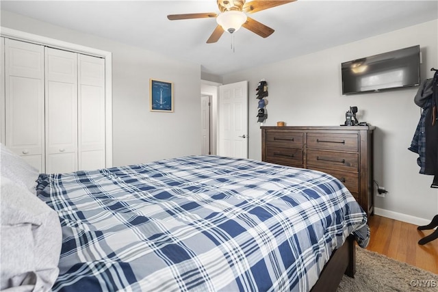 bedroom with ceiling fan, a closet, baseboards, and wood finished floors