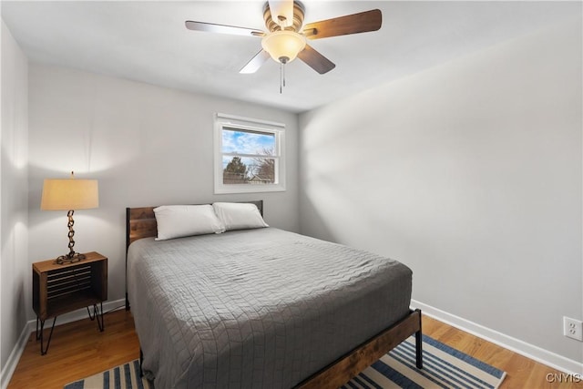 bedroom featuring light wood-style floors, ceiling fan, and baseboards