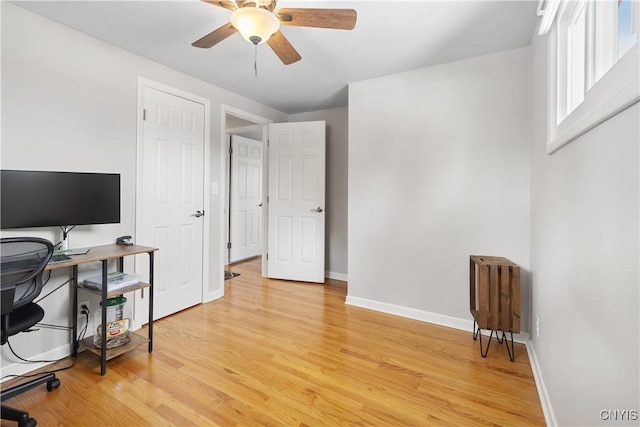 office area with light wood finished floors, ceiling fan, and baseboards