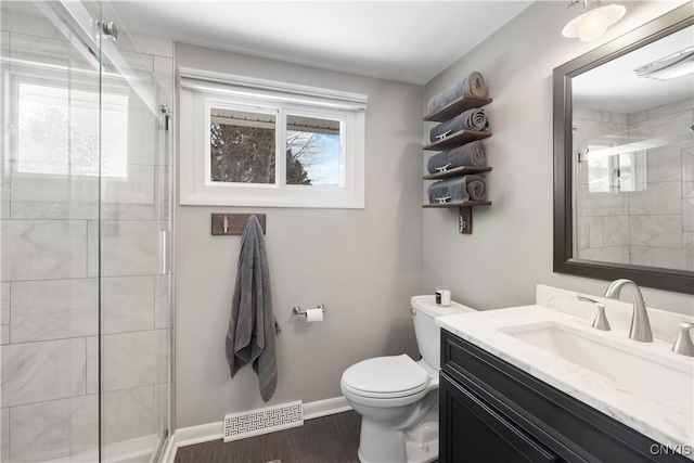 full bath with a stall shower, baseboards, visible vents, toilet, and vanity