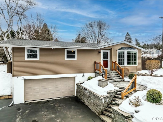 single story home with an attached garage, driveway, and roof with shingles