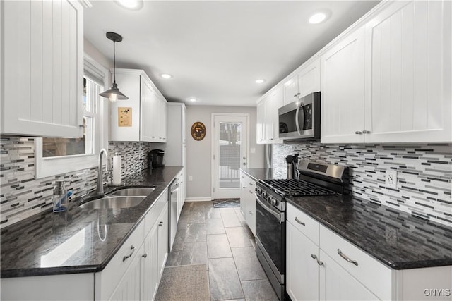 kitchen featuring stainless steel appliances, a healthy amount of sunlight, white cabinets, and a sink