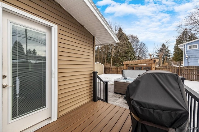 wooden deck with a grill and a fenced backyard