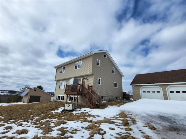 view of front of home with a garage, stairway, and an outbuilding