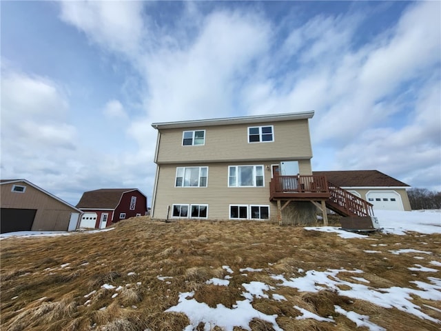 snow covered rear of property with stairway