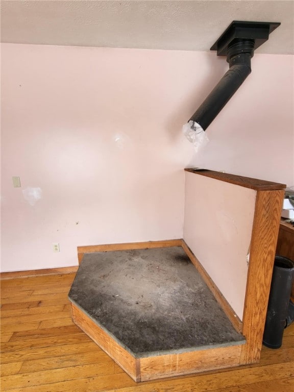 stairway with hardwood / wood-style floors and baseboards