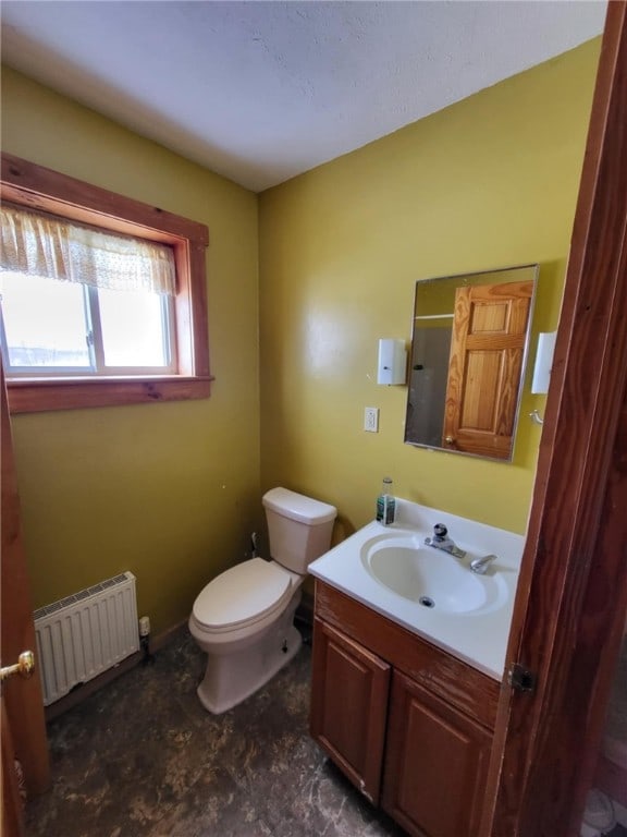 bathroom with radiator, toilet, and vanity