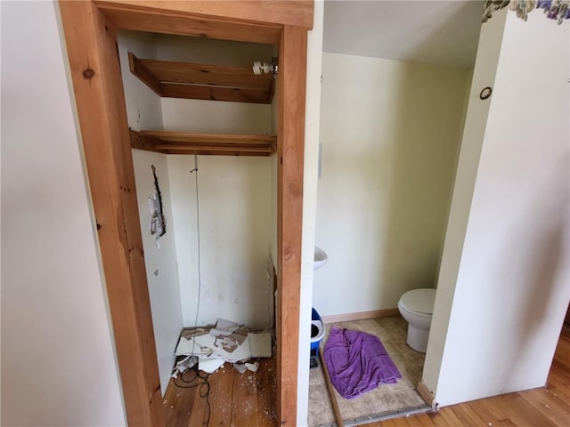 bathroom featuring baseboards, toilet, and wood finished floors